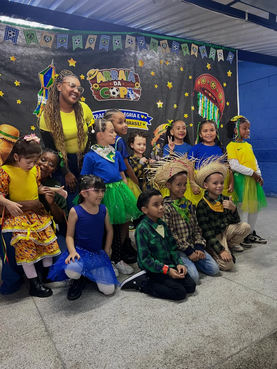 Crianças e equipe em registro da Festa Junina